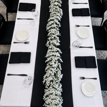 Load image into Gallery viewer, Aerial view of a large White Faux Baby's Breath garland installation styled along a long black and white corporate event table in Adelaide, creating one continuous centerpiece for a formal dinner setting.