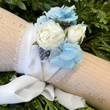 Load image into Gallery viewer, Handcrafted Blue Mirage Adelaide's Dream Corsage by Floral Atelier Australia, featuring three silk spray roses, dried blue hydrangea, and silk berries, tied with a long white chiffon ribbon.