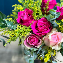 Load image into Gallery viewer, This cheerful and uplifting posy does not leave anyone indifferent. It is a neatly decorated miniature arrangement presented in a beautiful round fishbowl glass vase. The flowers seem to jump out and smile happily at anyone who looks at them. As a florist, I carefully place each bloom with intention, bringing the posy to life so that the roses appear to look directly at you.
This vibrant combination of bright hot pink and soft pink roses radiates energy and joy, designed to lift the mood. It is a perfect g