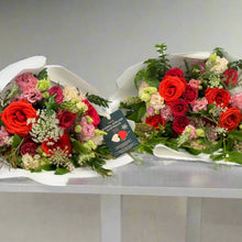 Load image into Gallery viewer, A comparison of the Amore Bouquet in two sizes: the standard size featuring a balanced mix of Ferrari red roses, wine-toned blooms, and seasonal flowers, and the deluxe size showcasing a fuller arrangement with more roses. Both are elegantly wrapped in white paper and tied with velvet ribbons, making them perfect romantic gifts.
