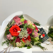 Load image into Gallery viewer, The Amore Bouquet in standard size, featuring Ferrari red roses, wine-toned blooms, and seasonal flowers, wrapped in white paper with velvet ribbons. Includes flower food for freshness.
