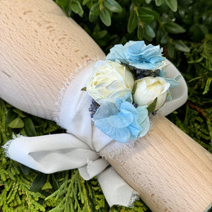 Close-up of Blue Mirage Adelaide's Dream Corsage highlighting the delicate white chiffon ribbon and the intricate arrangement of silk flowers and dried blue hydrangea.