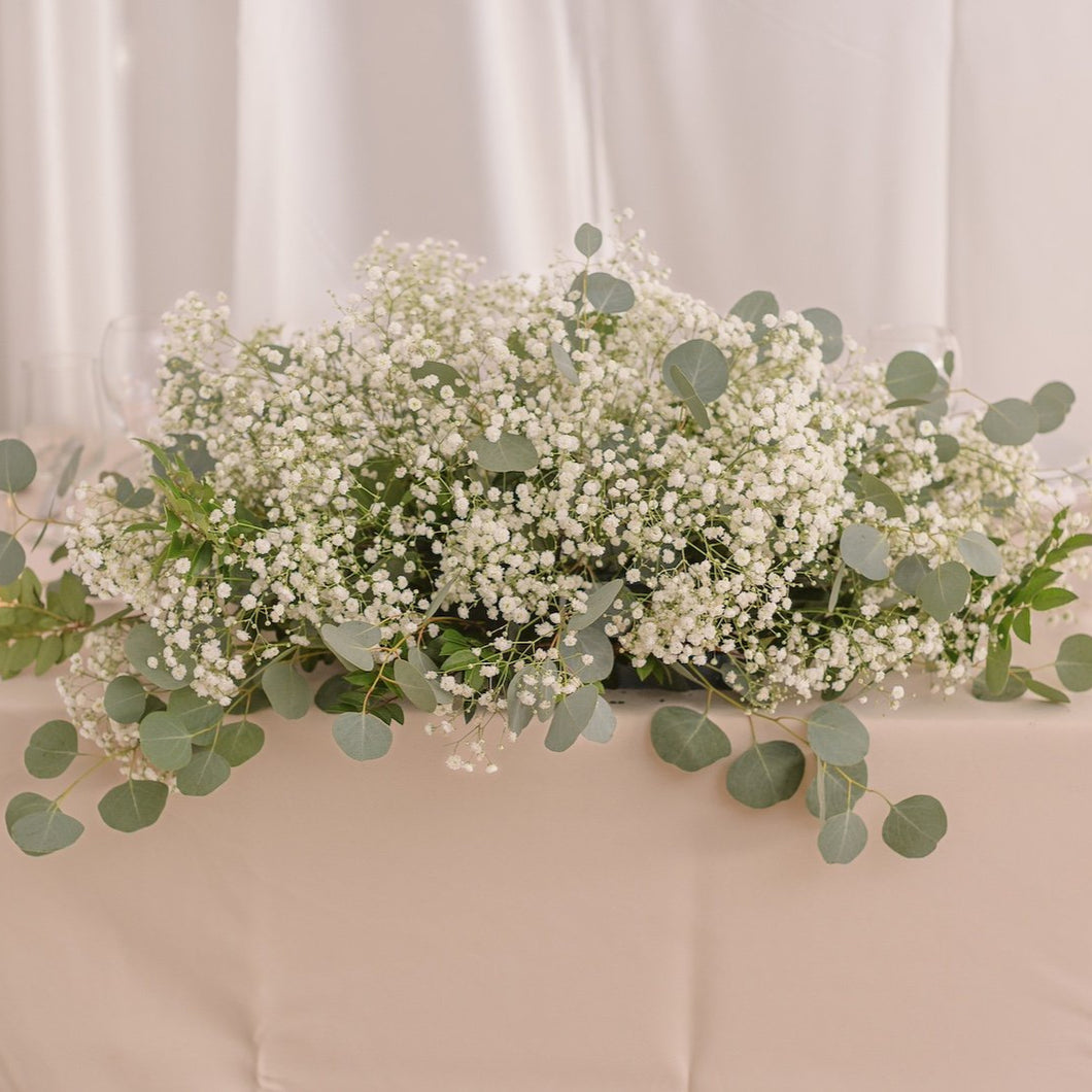 Long and low baby’s breath centerpiece with greenery for bridal or sweetheart table – Floral Atelier Australia