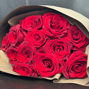 Classic Dozen Dark Red Rose Bouquet featured 12 premium dark red roses wrapped in chocolate brown paper. Close up image