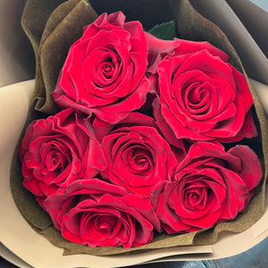 Classic Half Dozen Dark Red Rose Bouquet wrapped in chocolate brown paper. Close up image