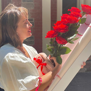 In a quiet Adelaide courtyard, she gazes at the Dozen Ferrari Red Roses, their beauty matched only by the tenderness with which she holds the plush bunny, a perfect endnote to Floral Atelier Australia's story of love, delivered with care and same day flower delivery
