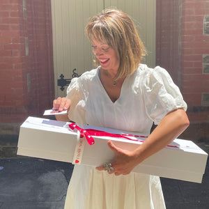 Anticipation shines in her eyes as she gently unties the ribbon of the Dozen Ferrari Red Roses & Plush Bunny in a Box from Floral Atelier Australia, a prelude to the romantic discovery within, offered with love and same day flower delivery in Adelaide