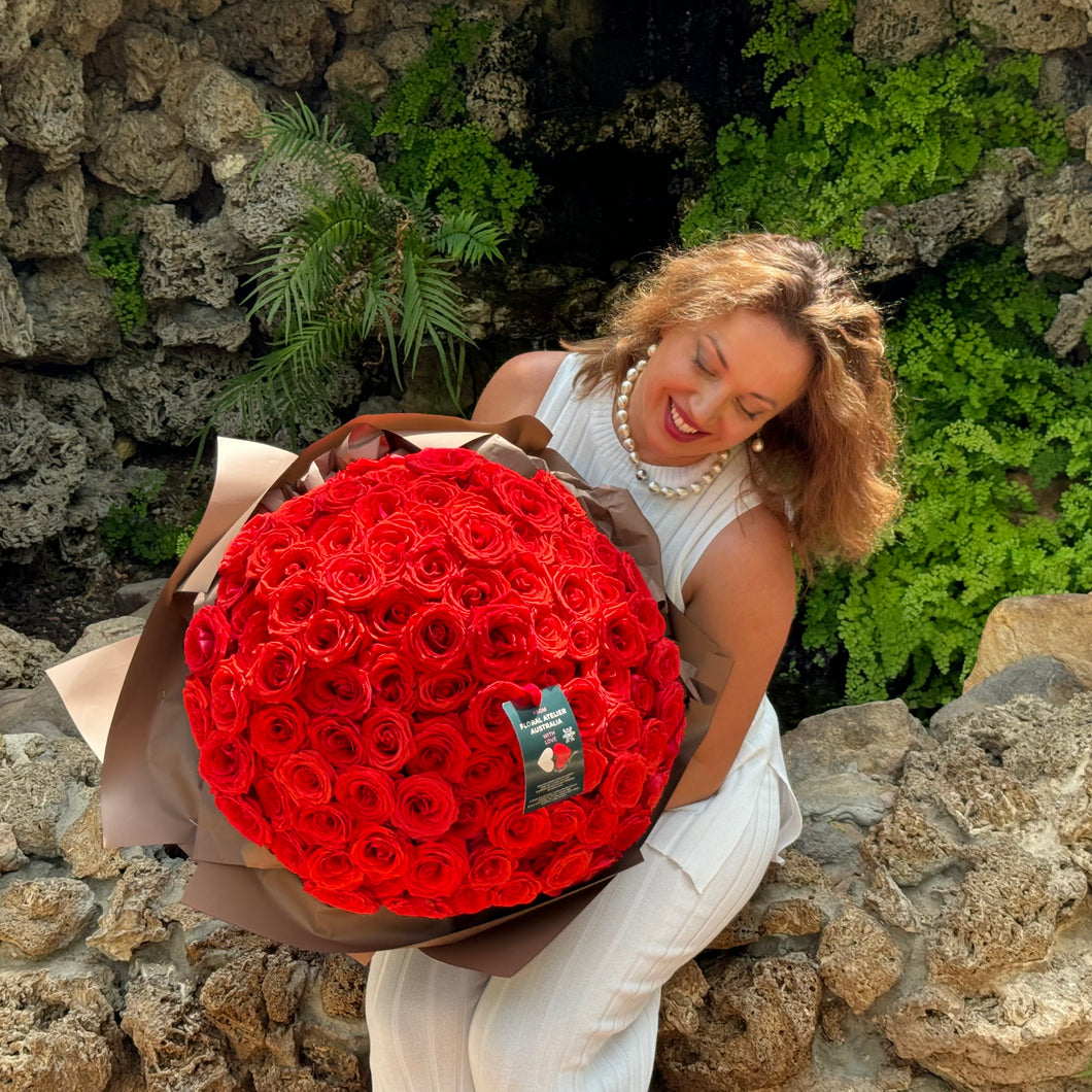 Radiant smile meets the splendor of 100 red roses, as Floral Atelier Australia presents the Elegant 100 Ferrari Red Roses Bouquet, wrapped in luxury and ready for same day flower delivery in Adelaide. This grand arrangement, hand-delivered with care, is the ultimate expression of love from Adelaide's esteemed florist