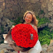 Load image into Gallery viewer, A joyful recipient admires the Elegant 100 Ferrari Red Roses Bouquet from Floral Atelier Australia, expertly arranged and beautifully wrapped, symbolizing a grand gesture of love, available for same day delivery by a leading florist in Adelaide
