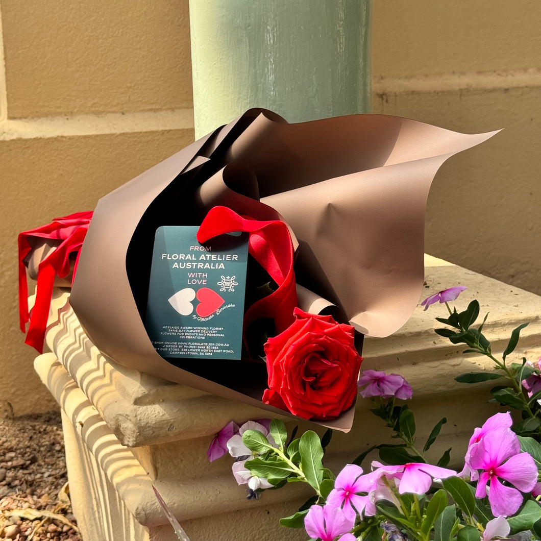 Floral Atelier Australia presents the Elegant Ferrari Red Rose, a symbol of pure affection, wrapped with precision and adorned with a velvet ribbon. This single rose represents a timeless romantic gesture, available for same day flower delivery from the premier florist in Adelaide