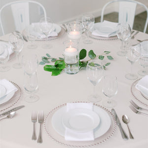 Floating candles in glass vases with fresh foliage – small wedding or event table decor by Floral Atelier Australia.