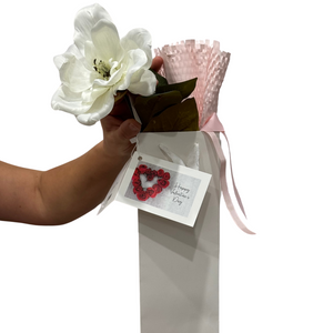 A beautifully wrapped bottle of  Paracombe Wines, presented in soft pink protective paper, adorned with a large white silk magnolia flower and tied with a pink ribbon. Includes a Valentine’s Day card and is placed in an elegant white wine gift bag.