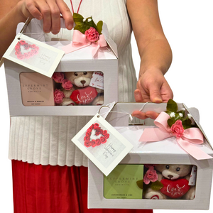 Close-up of the Gift One with a soft mini teddy bear and a Peppermint Grove Australia mini soy candle, elegantly presented in a white gift box decorated with pink silk flowers and a 'Happy Valentine’s Day' card