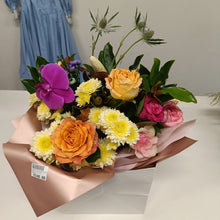 Load image into Gallery viewer, a bouquet of flowers roses and orchid and magnolia in a paper bag
