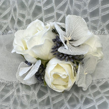 Load image into Gallery viewer, Close-up of Blue Mirage Adelaide&#39;s Dream Corsage highlighting the delicate white chiffon ribbon and the intricate arrangement of silk flowers and dried blue hydrangea.
