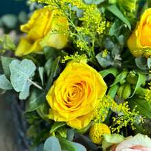 Load image into Gallery viewer, A close-up view of the Sunshine Rose Arrangement, highlighting the vibrant pink and yellow roses, delicate alstroemerias, and cheerful yellow billy buttons, accented with golden rod and lush blue gum foliage. The detailed shot captures the fresh, radiant colors and intricate textures of the flowers, showcasing the bouquet&#39;s lively and elegant composition.

