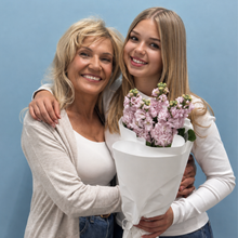 Load image into Gallery viewer, Woman holding a bouquet of flowers with another woman against a blue background
