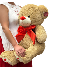 Load image into Gallery viewer, Oversized 90 cm Teddy Bear Deluxe with soft beige fur, a bright red bow, and heart accents on its paws. This plush toy is perfect for making a bold, heartfelt statement on Valentine’s Day or paired with luxurious bouquets for an unforgettable gift.
