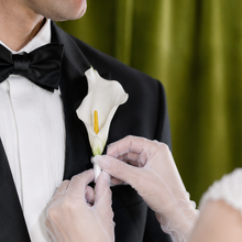 Load image into Gallery viewer, Bride attaching a white Calla Lily magnetic boutonnière to the groom made by Floral Atelier Australia.
