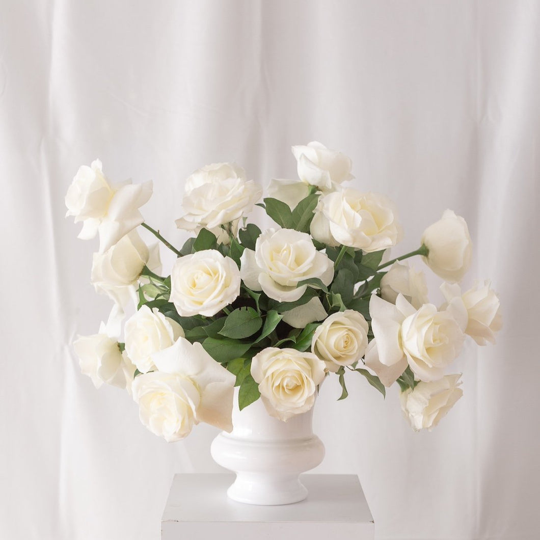 White rose centerpiece in classic urn – elegant wedding altar or venue decor by Floral Atelier Australia.