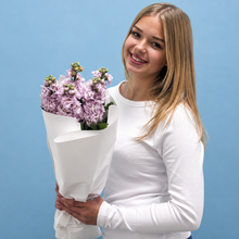 Load image into Gallery viewer, Woman holding a bouquet of purple flowers against a blue background
