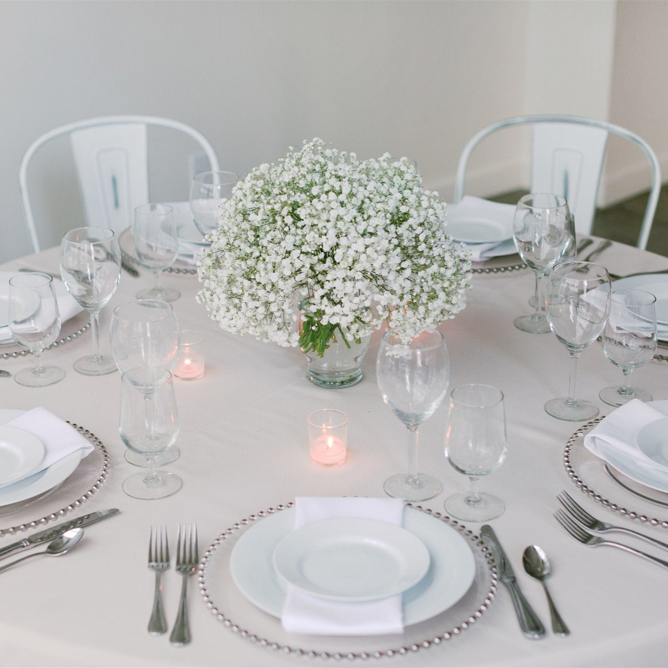 Large baby’s breath centerpiece in a glass jar with 4 votive candles on a round table – Floral Atelier Australia, Adelaide