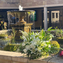 Load image into Gallery viewer, The Pure Life Arrangement in deluxe size, placed with care at Pasadena Cemetery. The elegant white blooms and lush greenery offer a beautiful tribute in a peaceful resting place.
