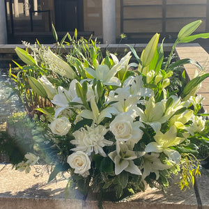 An image of the Pure Life Arrangement in deluxe size, displayed at Pasadena Cemetery. The floral tribute’s serene white flowers and vibrant greenery blend harmoniously with the tranquil surroundings.