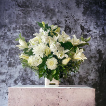 Load image into Gallery viewer, A serene arrangement of white blooms and lush greenery, representing the Pure Life Arrangement in standard size. Ideal for expressing sympathy and support with its elegant and comforting presence.
