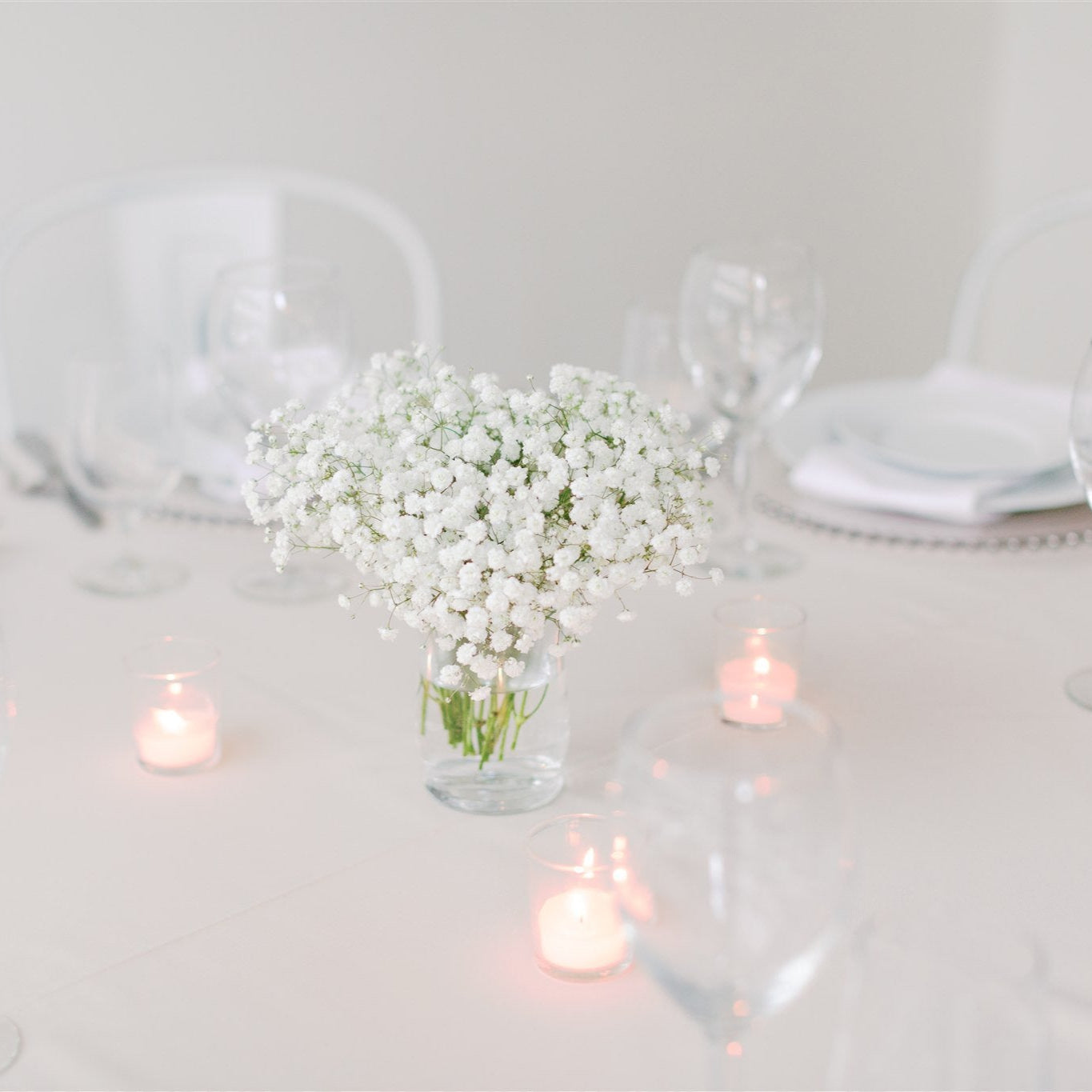 Small baby’s breath centerpiece in a glass jar with 3 tea candles – ideal for cocktail tables and intimate weddings by Floral Atelier Australia, Adelaide