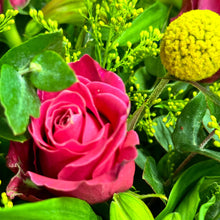 Load image into Gallery viewer, A close-up view of a vibrant rose arrangement featuring fresh pink and hot pink roses with yellow billy buttons. The image showcases the beautiful textures and vivid colors of the flowers, set against lush green foliage of golden rod and blue gum.
