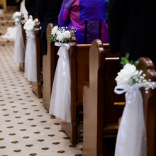 Load image into Gallery viewer, Wedding Ceremony Chair Flowers with white faux flowers and premium tulle styled on church pews at St Paul's Catholic Church, Urrbrae, Adelaide by Floral Atelier Australia.
